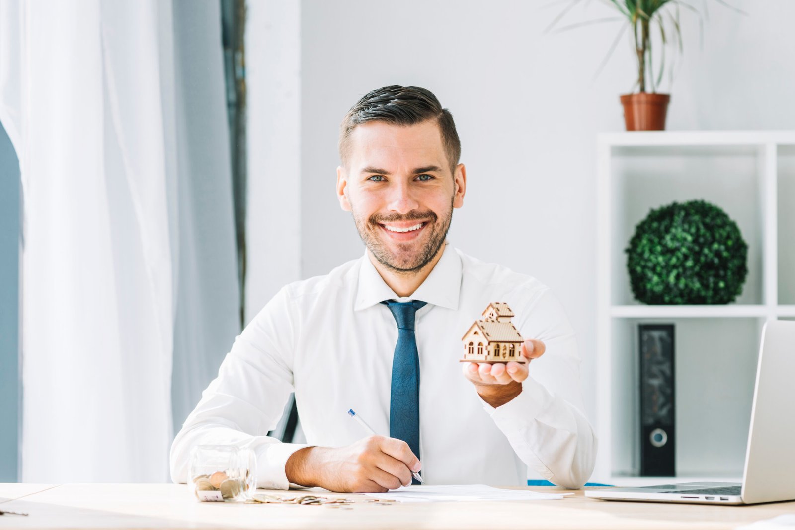 cheerful-real-estate-agent-showing-toy-house cheerful-real-estate-agent-showing-toy-house
